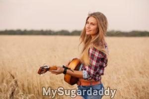 mulher loira tocando violao em campo melhor perfil