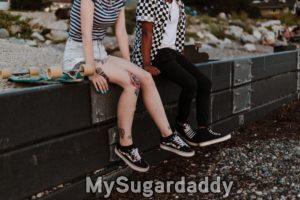 amigos jovens com skate sentados em muro