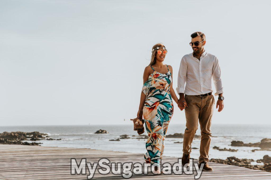 Casal passeando de maos dadas na praia